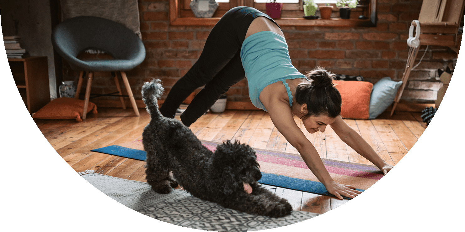 Woman and her dog doing the downward dog yoga pose 