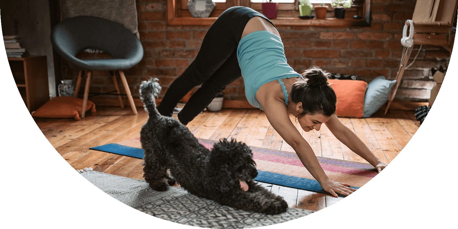 Woman and her dog doing the downward dog yoga pose