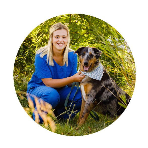 Hunter, smiling, kneeling and holding her dog