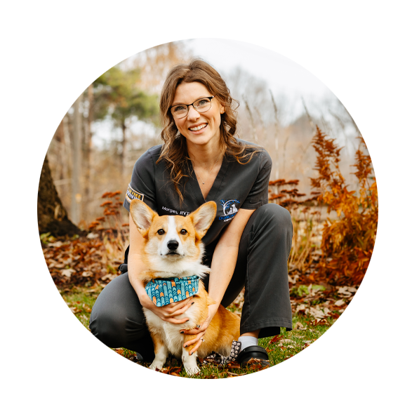 Morgan smiling, kneeling and holding her dog